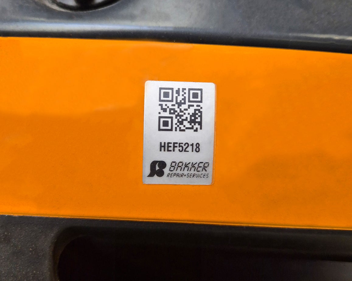 Close-up van een gereedschapbeheer label met QR-code, uniek nummer en bedrijfslogo op een heftruck