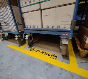 Geel vloerlabel met locatiecode en DataMatrix code in een magazijnomgeving