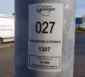 Reflecterend label van gemeente op lantaarnpaal