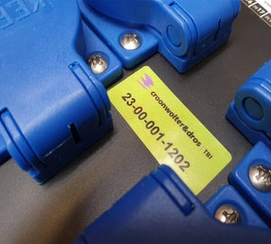 Geel Full-color Print & Laminate label met tekst en nummering geplaatst tussen blauwe connectoren