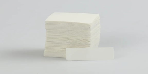 Stapel blanco vellen ADC beschermlaminaat met een los vel op de voorgrond