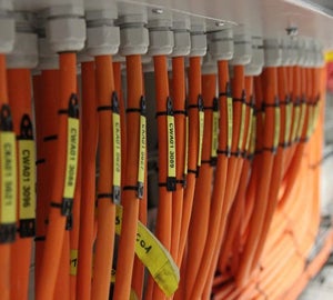 Gele bedrukbare krimpkousen met kabelcodes op oranje kabels bij kabelwartels