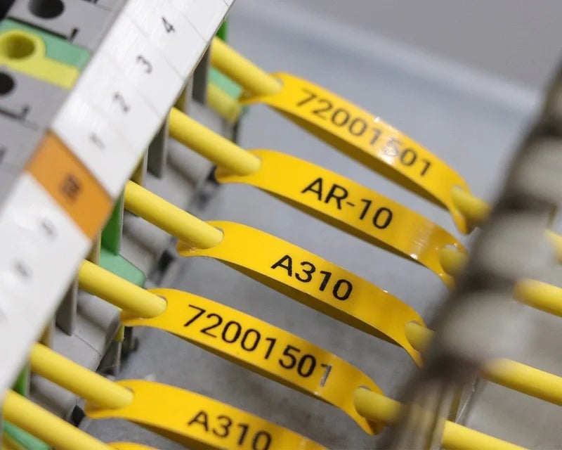 Gele wire tags met adercodes op gele aders in schakelkast