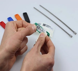 Handen plaatsen een Print & Protect label in een groene HoseTag