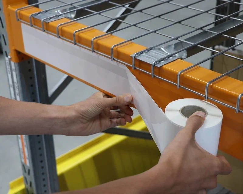 Aanbrengen van het SwapLabel op een oranje magazijnstelling