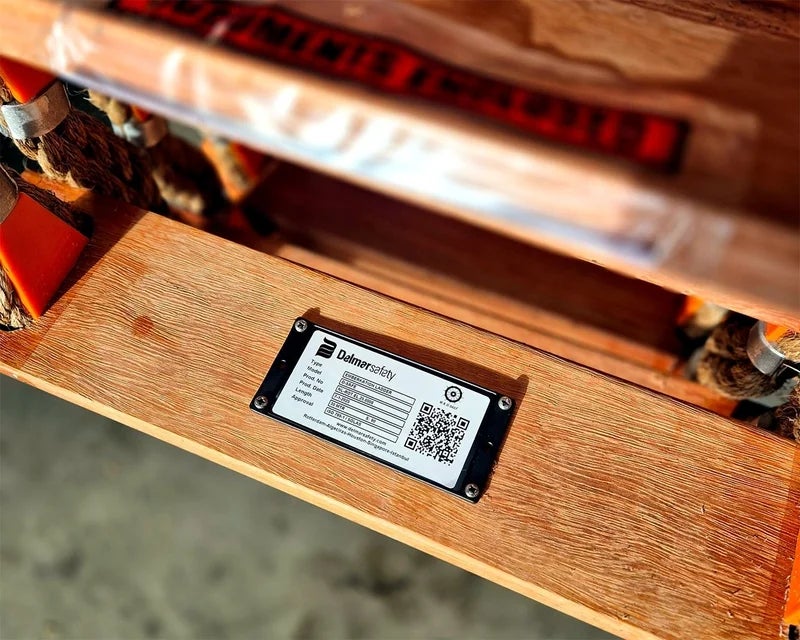 Typeplaathouder met typeplaat bevestigd op een houten oppervlak met schroeven