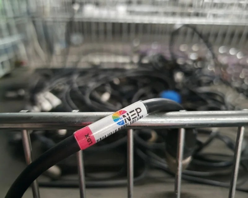 Zwarte kabel met full-color wikkellabel in metalen bak