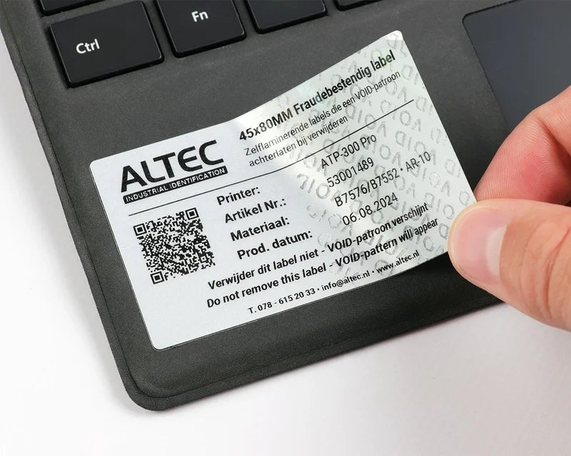 Fraudebestendig Print & Laminate label op laptop met zichtbaar VOID-patroon na gedeeltelijke verwijdering