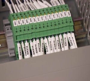 Witte brady sleeves met adercodes op aders bij groene klemmenstroken in schakelkast
