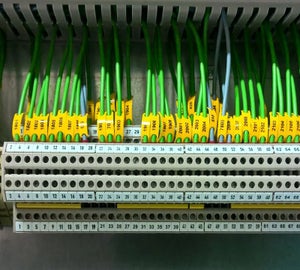 Gele Wire tags met nummercodes op groene aders aangesloten op klemmenstroken
