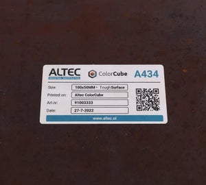 Full-color label met tekst en QR-code aangebracht op ruwe metalen ondergrond