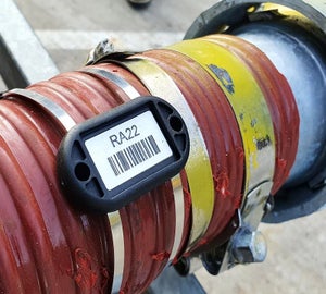 ChainTag bevestigd met RVS kabelbandjes rond een industriële buis voorzien van barcode