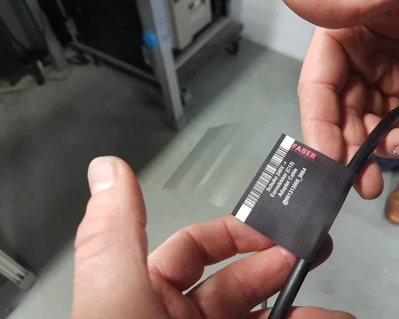 Transparant beschermlaminaat wordt over een full-color wikkellabel gevouwen op een kabel voor extra bescherming