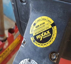 Rond NEN 3140 keuringslabek aangebracht op industrieel materieel voor periodieke inspectie
