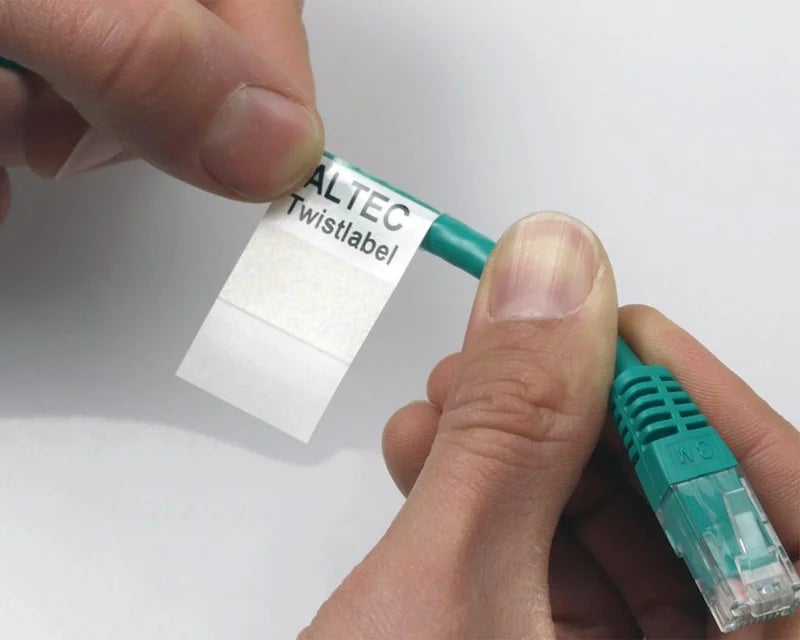 Handen die een TwistLabel aanbrengen op groene netwerkkabel