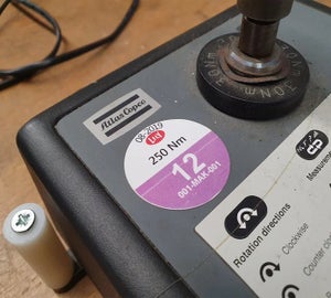 Rond keuringslabel met inspectiedatum en specificaties op industrieel meetapparaat