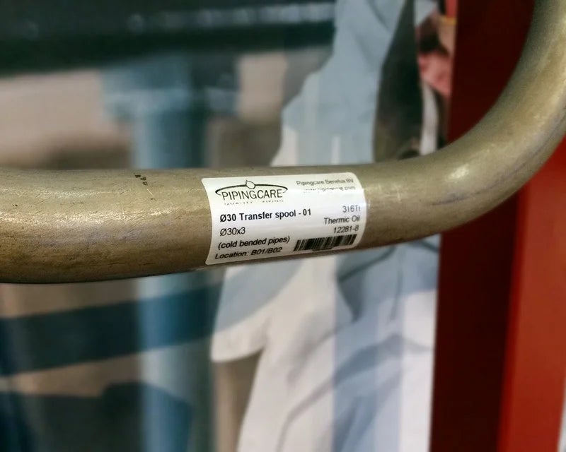 Typeplaatje met technische specificaties en barcode op stalen buis