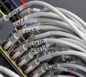 Witte kabellabels met identificatiecodes op witte patchkabels in patchkast