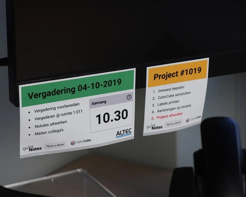 Full-color sticky notes met planning en projectinformatie aangebracht op metalen kast