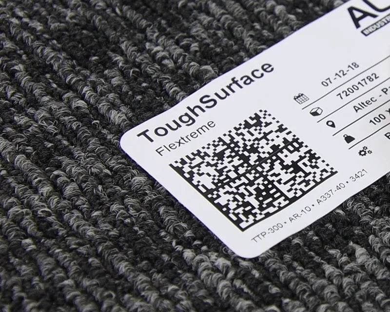 ToughSurface Flextreme label met QR-code aangebracht op ruw tapijtoppervlak