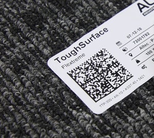 ToughSurface Flextreme label met QR-code aangebracht op ruw tapijtoppervlak