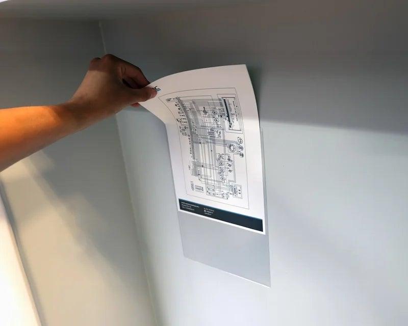 Persoon haalt een technische tekening uit een transparante documenthouder