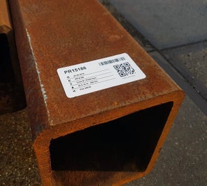 Wit ToughSurface Extreme label met QR-code aangebracht op geroest staalprofiel