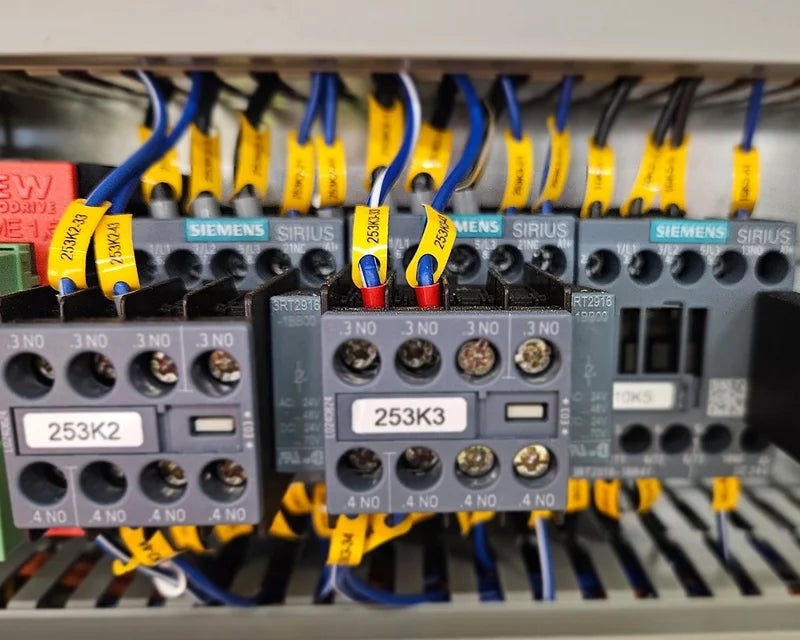 Gele wire tags met adercodes op aders bij contactoren