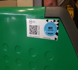 Keuringslabel met QR-code en inspectiesticker aangebracht op groene machinebehuizing