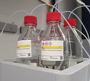 GHS labels met gevarensymbolen aangebracht op glazen laboratoriumflessen