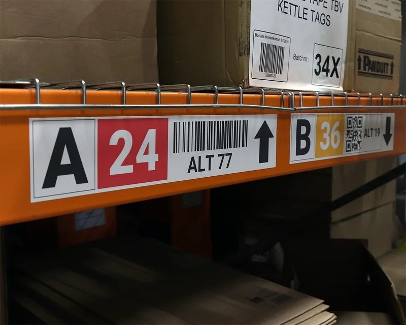 Full-color magneetband met tekst, nummers en barcodes op een oranje magazijnstelling 