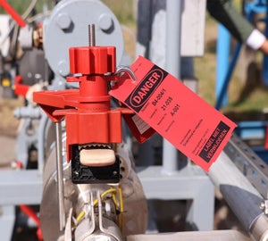 Rode lockout tag met waarschuwing bevestigd aan een industriële installatie