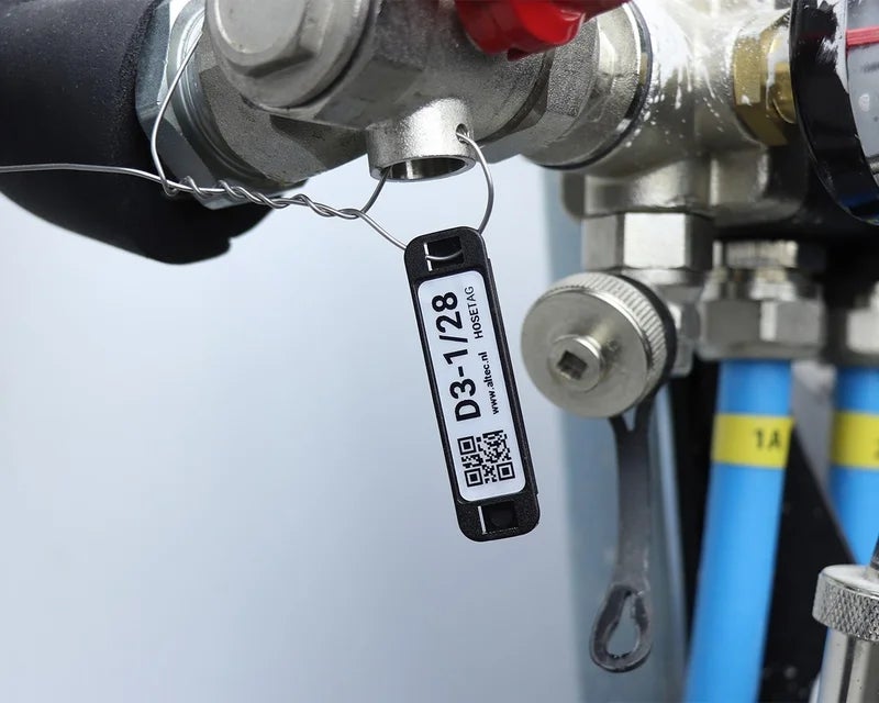 HoseTag met tekst en QR-code gemonteerd aan een industriële afsluiter voor duurzame identificatie