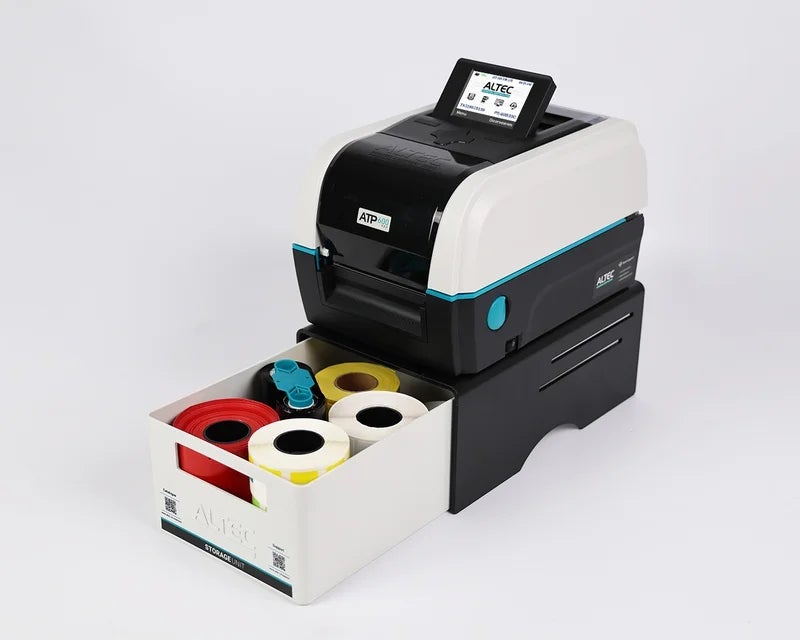 ATP-600 Pro labelprinter met Storage Unit gevuld met verschillende rol labels en inktfolies