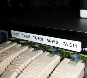 Witte ResoPrint labels met poortcodering op patchpaneel met aangesloten netwerkkabels