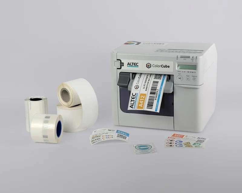 ColorCube labelprinter met verschillende labelrollen en voorbeelden van full-color labels