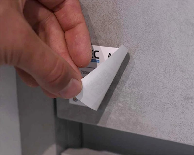 Full-color sticky note wordt losgetrokken van metalen oppervlak om kleefkracht te tonen