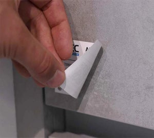 Full-color sticky note wordt losgetrokken van metalen oppervlak om kleefkracht te tonen