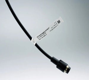 Witte kabelvlag met bedrijfsgegevens en QR-code op zwarte kabel met connector