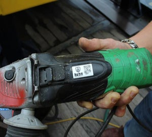 Asset label met logo en QR-code op elektrisch gereedschap voor identificatie