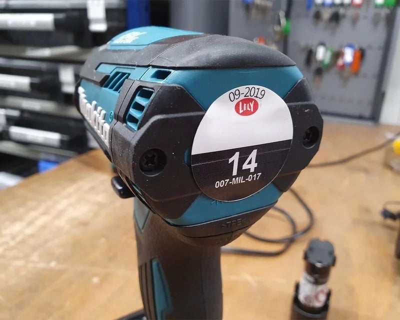 Rond full-color keuringslabel met datum en nummering op elektrisch handgereedschap