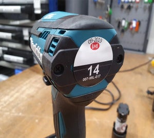 Rond full-color keuringslabel met datum en nummering op elektrisch handgereedschap