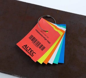 Hittebestendige tags in rood, geel, oranje, wit, groen en blauw met barcode op stalen ondergrond