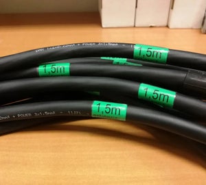 Groene wikkellabels met kabellengte op zwarte kabels voor kabelbeheer