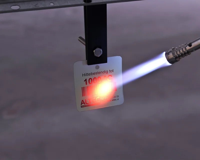 Witte HotTag die wordt blootgesteld aan een brander om bestendigheid tot 1000 °C te testen