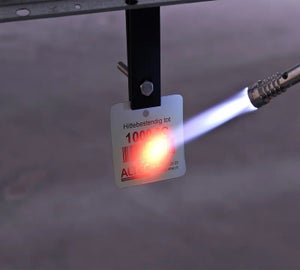 Witte HotTag die wordt blootgesteld aan een brander om bestendigheid tot 1000 °C te testen