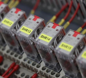 Gele componentlabels met identificatiecodes aangebracht op relaismodules in schakelkast