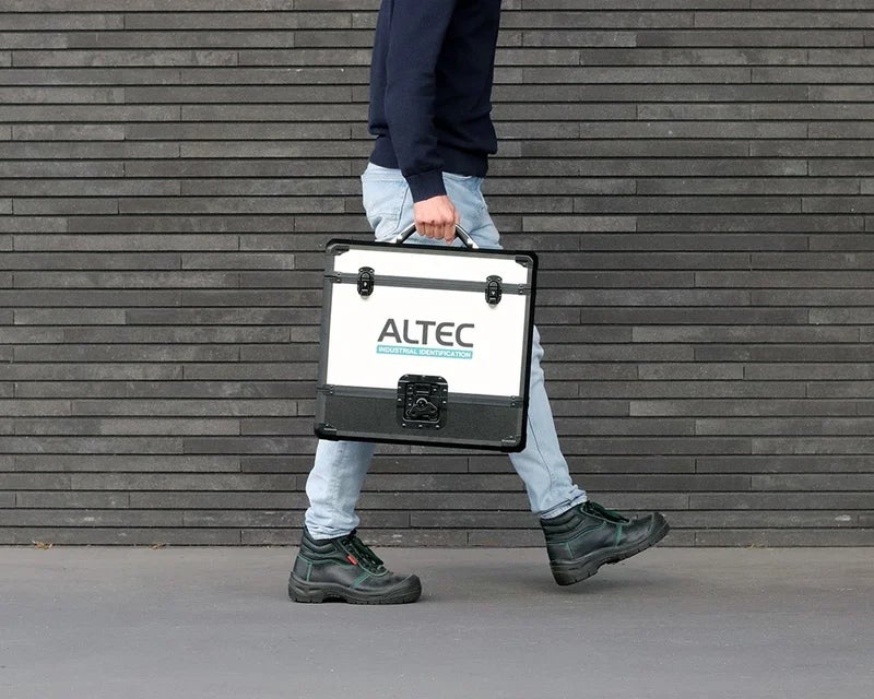 Persoon draagt een ATP Draagkoffer, waarmee een labelprinter en benodigdheden eenvoudig naar verschillende werklocaties kunnen worden meegenomen